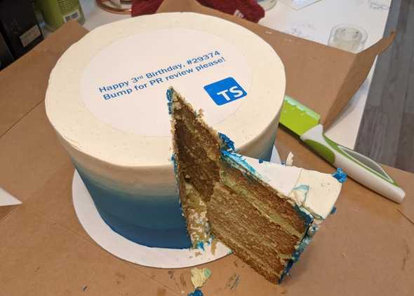 Fancy blue and white circular cake with text "Happy 3rd Birthday, #293374" and "Bump for PR review please!" above the TypeScript logo